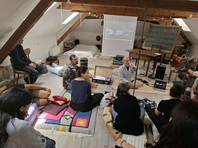 Discussion in the attic studio with a projection screen and blackboard