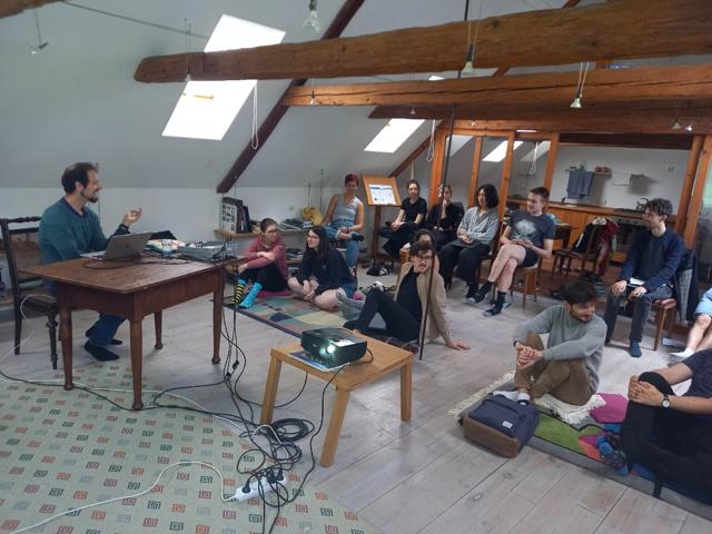 Participants sitting in a circle around a speaker in the attic studio
