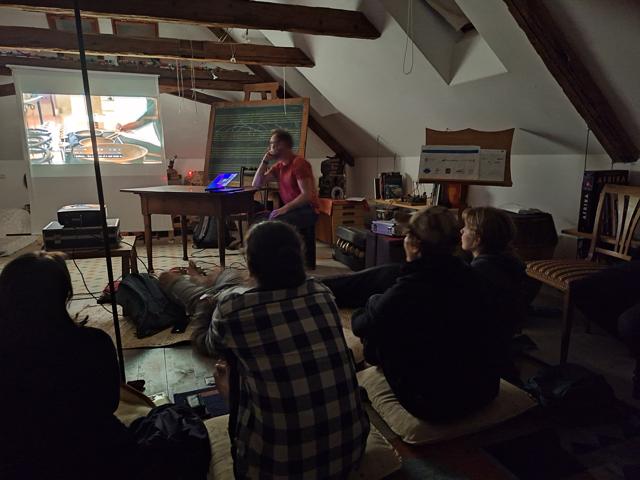 Participants watching a video projection in the dim attic